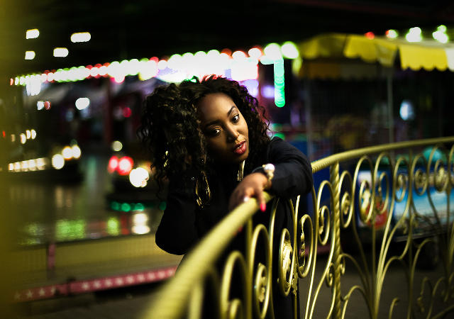 Фотография темнокожей девушки, на фотографии девушка стоит на мосту в луно парке