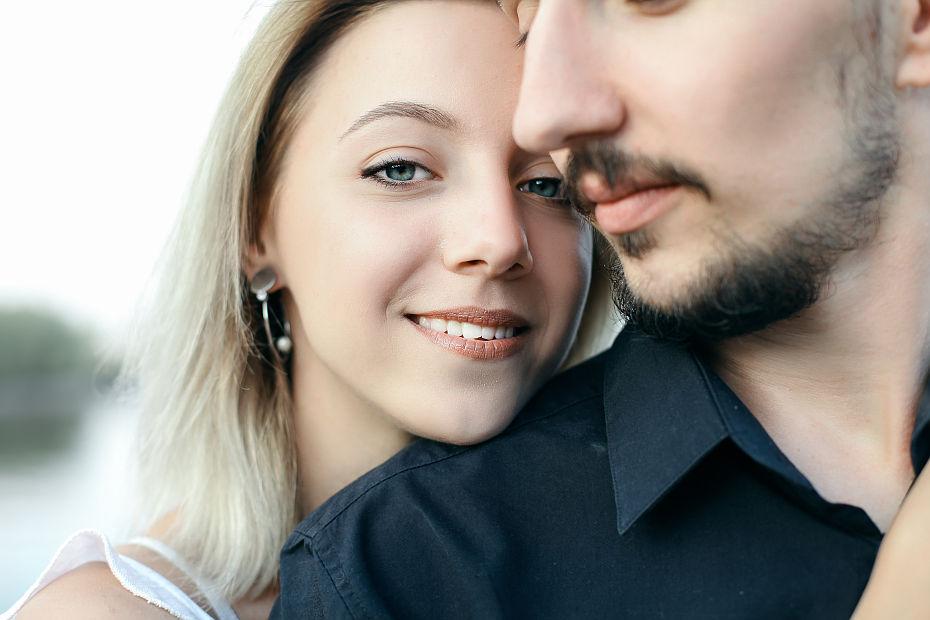 Фотография молодой пары лет тридцати, девушка блондинка улыбается она положила парню голову на плечо, парень с бородой и усами
