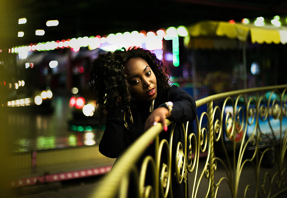 Фотография темнокожей девушки, на фотографии девушка стоит на мосту в луна парке